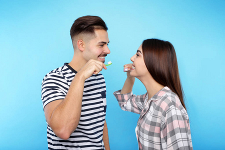 生情侣彩色背景下的快乐情侣刷牙照片