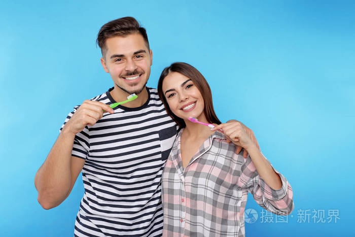 彩色背景下的快乐情侣刷牙