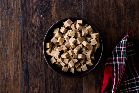 生的有机红糖立方体在木碗里准备吃。 食品。