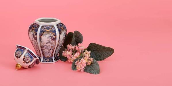 经典东方花瓶，茉莉花枝，隔离在粉红色珊瑚背景上