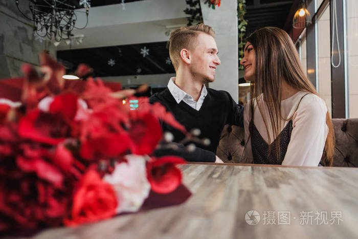 恋爱中的年轻夫妇在咖啡馆里浪漫约会的男人和女人坐在靠窗的桌旁桌子