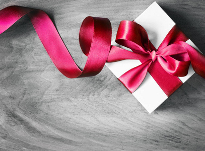 白色礼品盒和红色丝带与标签在木头背景。木板上的复古礼品盒, 可提供文字空间