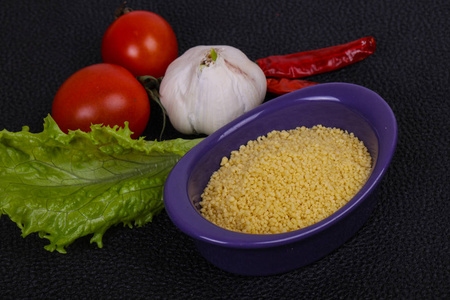 生粗麦粉放在碗里，沙拉叶，番茄和胡椒，准备加肉