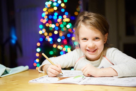 受启发的小女孩在桌子上画蜡笔或做家务