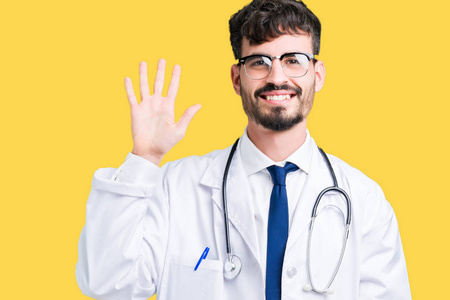 年轻的医生穿着医院的外套，在孤立的背景上，用手指举着五个手指，同时微笑，自信和快乐。