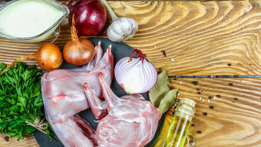兔子肉与蔬菜和香料在木制桌子背景。 自制传统烹饪食谱。 平视头顶。 顶部视图免费空间的文本。