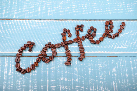 用咖啡豆在木制背景上拼出的咖啡
