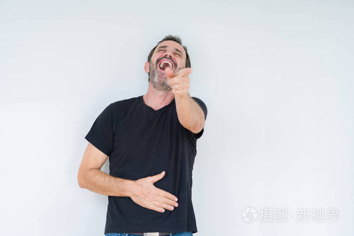 老人在孤立的背景下笑着用手指指着相机,用手捂住胸口,羞愧的表情