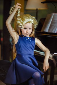可爱的小女孩弹钢琴，穿着复古摩扎特维格室内