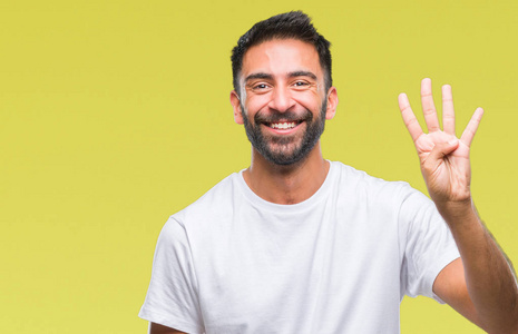 成年西班牙裔男子在孤立的背景上显示和指着第四个手指，同时微笑自信和快乐。
