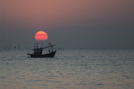 日落与渔船在邦森海滩在班森镇在普罗文茨昌布里在泰国。 2018年11月