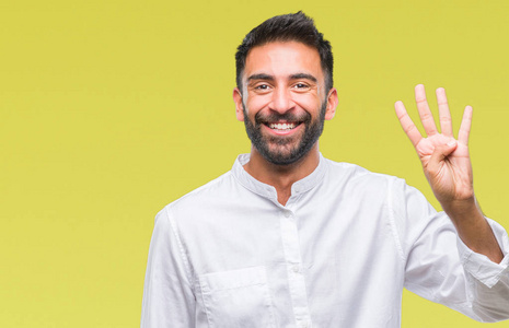 成年西班牙裔男子在孤立的背景上显示和指着第四个手指，同时微笑自信和快乐。