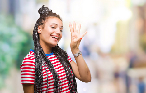 年轻的辫子非洲裔美国女孩在孤立的背景显示和手指第四，同时微笑自信和快乐。