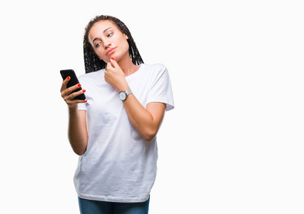 年轻的发辫非裔美国女孩用智能手机在孤立的背景下，严肃的脸，思考问题，非常困惑的想法