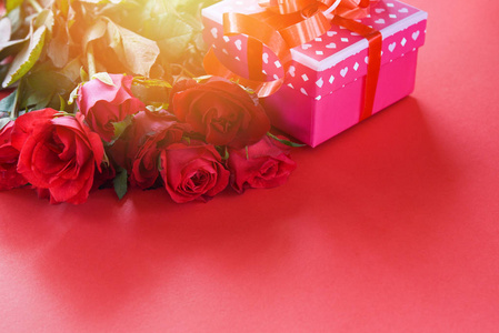 情人节礼物盒花爱情概念粉色礼品盒带丝带蝴蝶结红玫瑰花红色背景拷贝空间