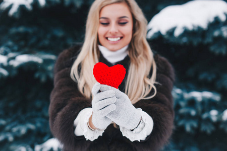 s heart in the woman hands on winter background.