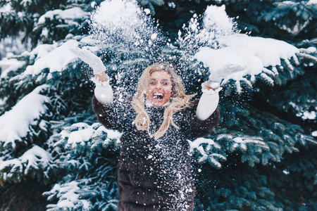 圣诞女孩户外肖像。 冬天的女人在公园里吹雪