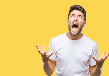 年轻的英俊男子在孤立的背景上疯狂和疯狂的喊叫和喊叫,咄咄逼人的