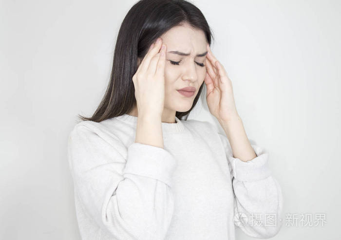 4年轻漂亮的女人在灰色背景下感到头痛