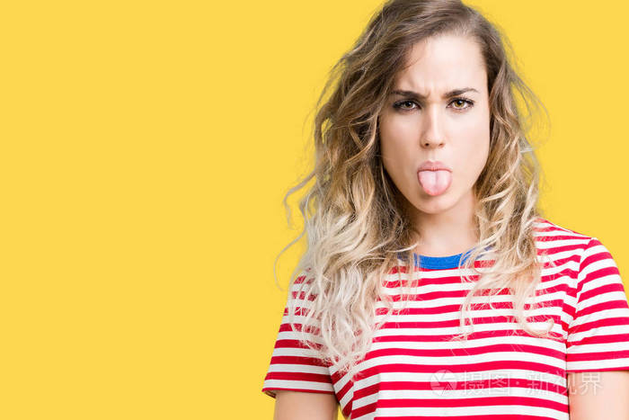 美丽的年轻金发女人在孤立的背景上伸出舌头以有趣的表情高兴情感概念