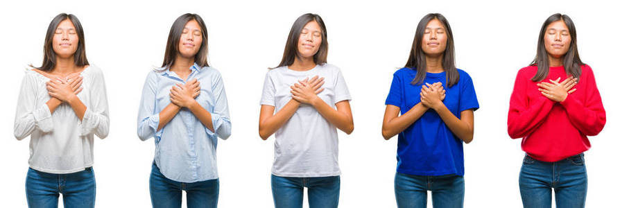 中国亚裔女性在孤立的背景下微笑,双手抱胸,闭着眼睛,表情感激.