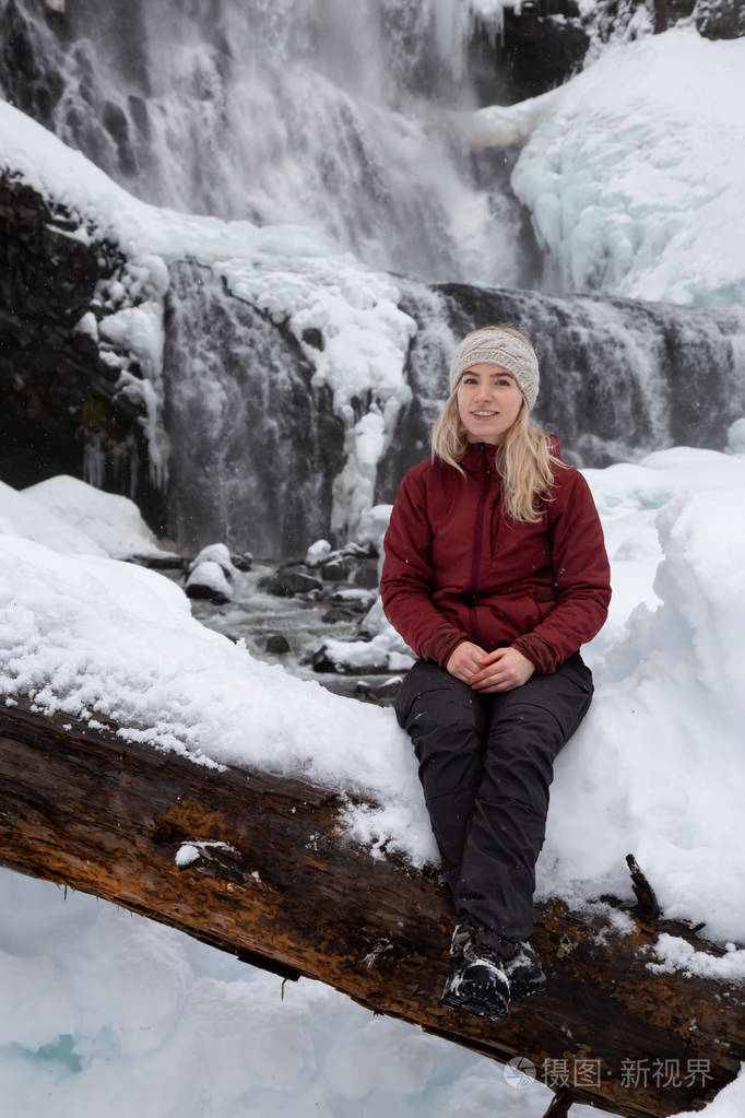 金发白种人女孩正在雪天欣赏美丽的加拿大冬季风景在亚历山大瀑布附近