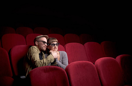 年轻夫妇坐在红色电影院照片