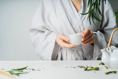 女性手拿茶杯在茶道中有选择的焦点。 亚洲食品主题背景。 冲泡和喝茶。