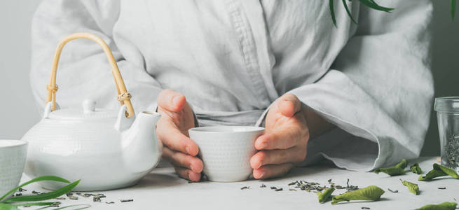 女性手拿茶杯在茶道中有选择的焦点。 亚洲食品主题背景。 冲泡和喝茶。