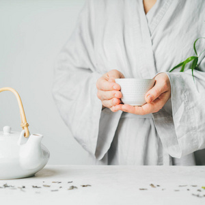 女人手里拿着一杯淡背景的茶