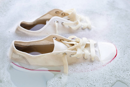 中快跑的马盘关-在上面女性的脚,上面放着木制背景花洗鞋前先浸泡鞋子