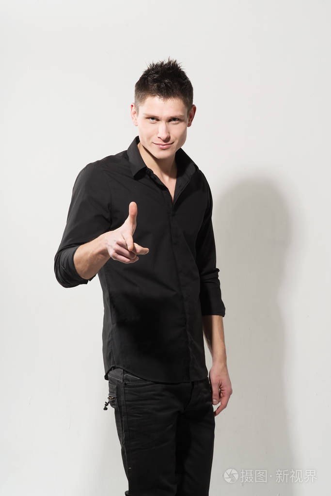 年轻白种人的肖像,穿着黑色衬衫,摆在白色背景上