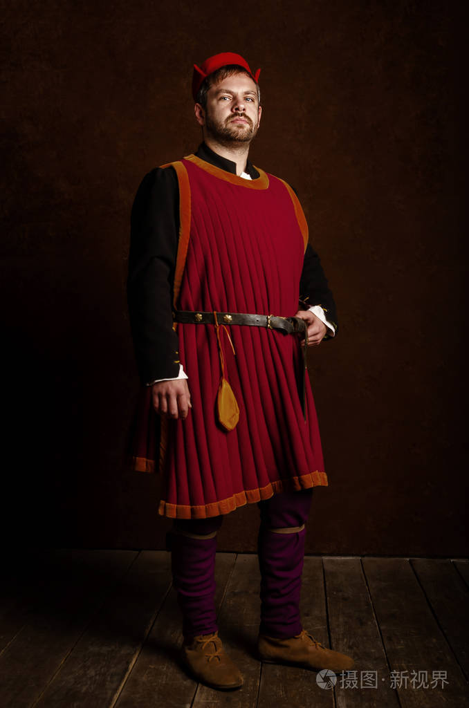 男人演员在15世纪的服装中世纪在一个古老的风格背景中世纪生活的爱好