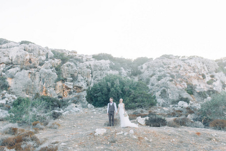 在塞浦路斯日落时在山上结婚。美丽的全景和幸福的夫妇。