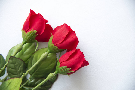 白色背景上的塑料红玫瑰。情人节概念。