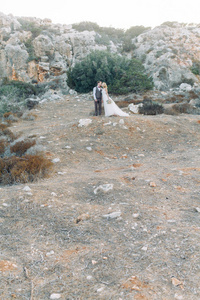塞浦路斯日落时山里的新婚夫妇。 美丽的全景和幸福的夫妇。
