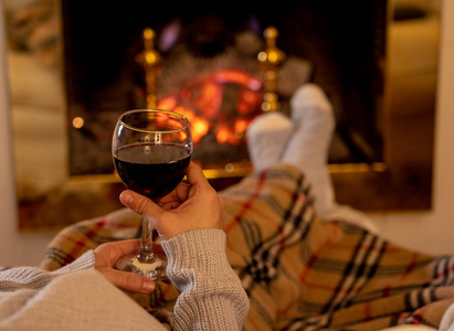在家喝红酒靠近微笑的女人,拿着和喝红酒杯,在开阔的柴火地方放松和