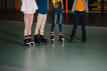 儿童在溜冰场上站立的溜冰鞋的局部视图照片