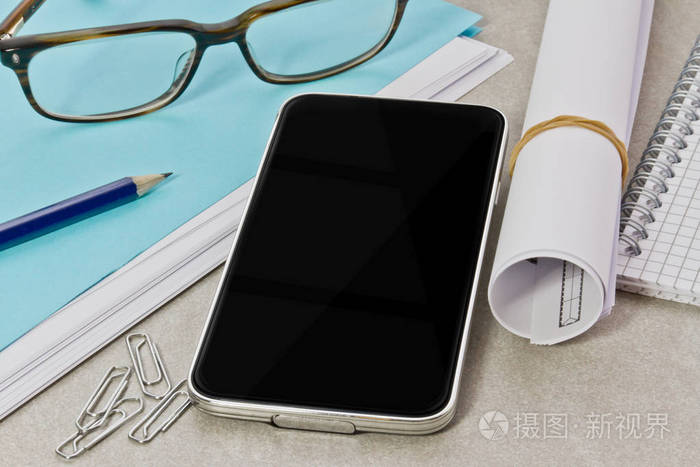 办公室内部办公桌上的现代智能手机
