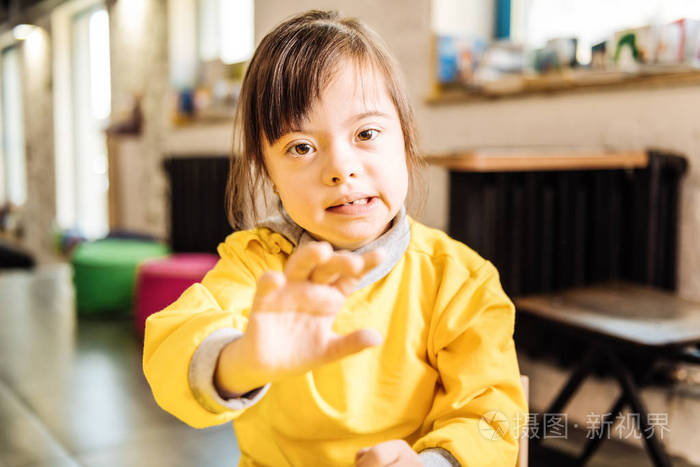 坐在窗边的黑发患有唐氏综合症的儿童