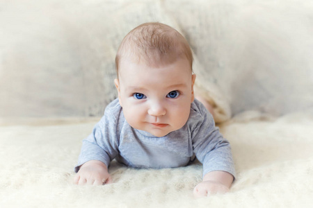 可爱的蓝眼睛婴儿向前爬。