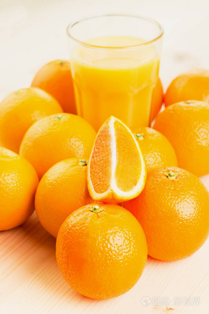 一杯新榨的橙汁和橘子切片在木制背景上健康的生活方式概念复制文本