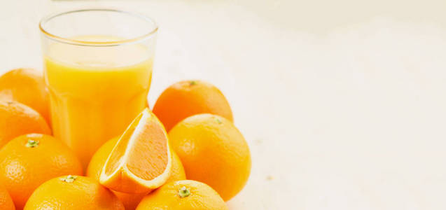 一杯新榨的橙汁和橘子切片在木制背景上。 健康的生活方式概念。 复制文本空间。