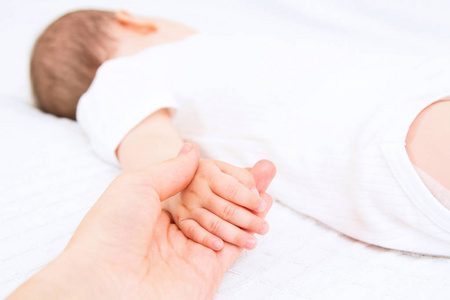 美丽的睡眠宝宝和妈妈的手白色背景