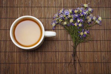 蓝花凉茶干束在竹桌背景上。 顶部视图，复制空间