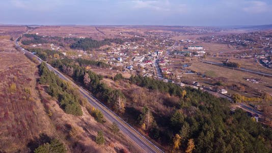 摩尔多瓦公路穿越村庄和森林山丘的鸟瞰图。