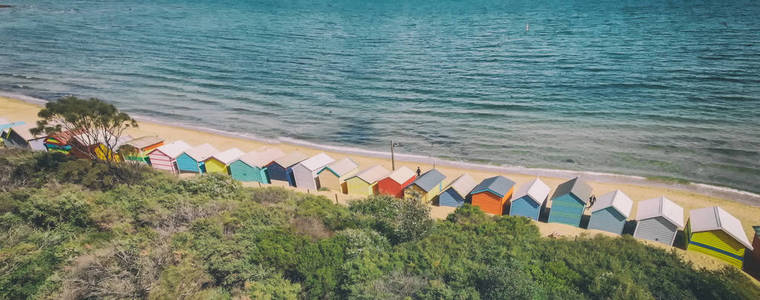 澳大利亚维多利亚州布莱顿海滩五颜六色的小屋全景。