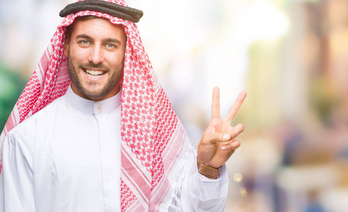 我耶年轻的英俊男子穿着凯菲耶在孤立的背景上,赞成做积极的手势,用手