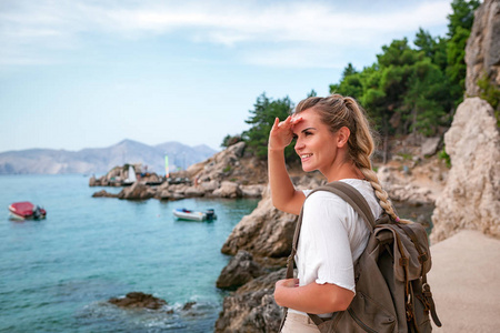 带背包的旅游妇女在旅行时发现了海岸