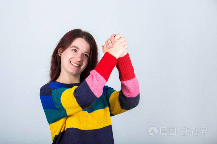 快乐休闲的年轻女子,双手并拢举起来,呈现出团结的象征,就像鼓励在